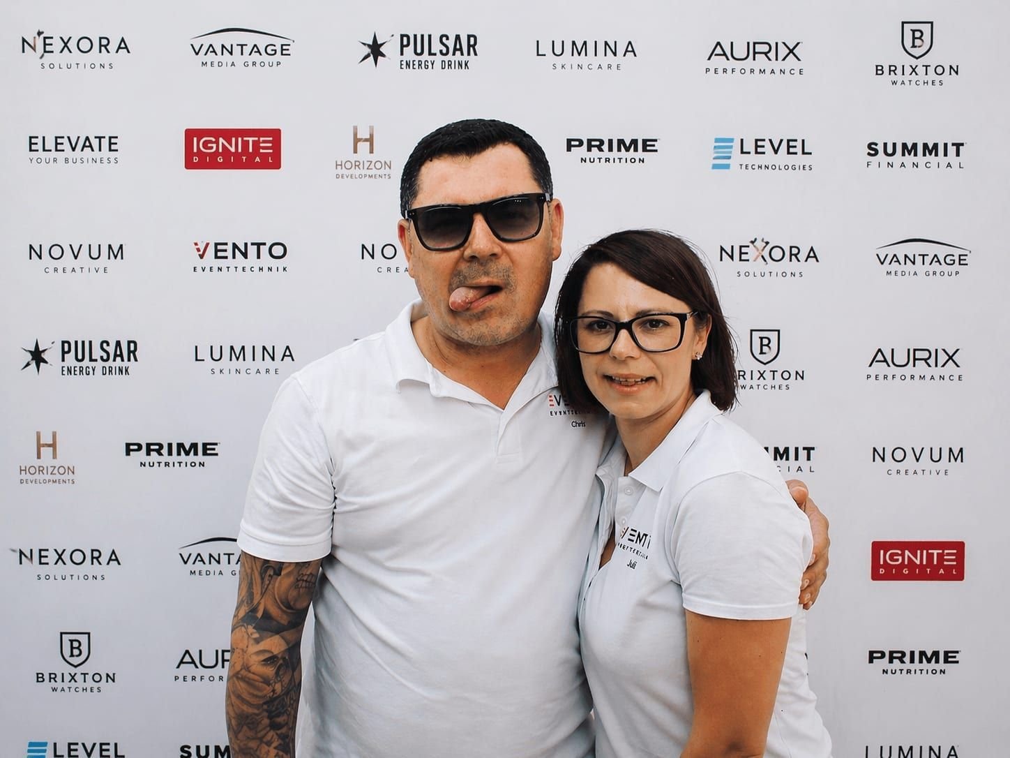 Aufnahme aus der Fotobox: zwei Personen vor der Sponsorenwand am Messestand